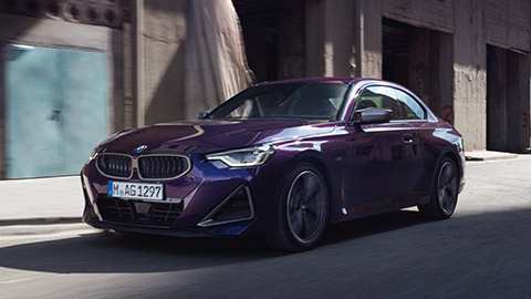 منظر أمامي ثلاثي الزوايا للسيارة BMW 2 Series Coupé G42 أثناء القيادة في الشارع