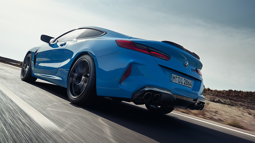 The BMW M8 Competition Coupé F92 LCI Facelift 2022 Daytona Beach blue uni three-quarter rear view driving on a highway