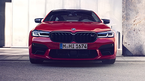 منظر أمامي ثلاثي الزوايا للسيارة BMW M Series BMW M5 F90 أثناء القيادة في الشارع