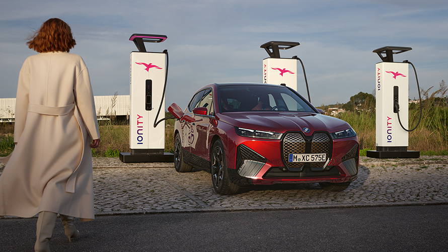 BMW Special Sales Sustainability Hub Overview BMW Charging Solutions BMW vehicle at charging station with woman in foreground