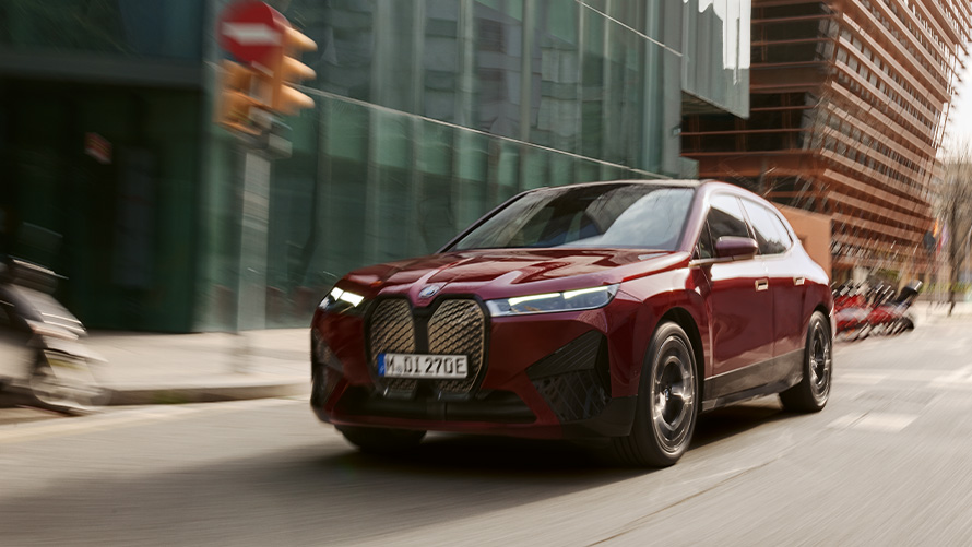 منظر أمامي ثلاثي الزوايا للسيارةBMW iX3 G08 2021  أثناء القيادة أمام مشهد لمنطقة تلال تظهر من خلف الضباب